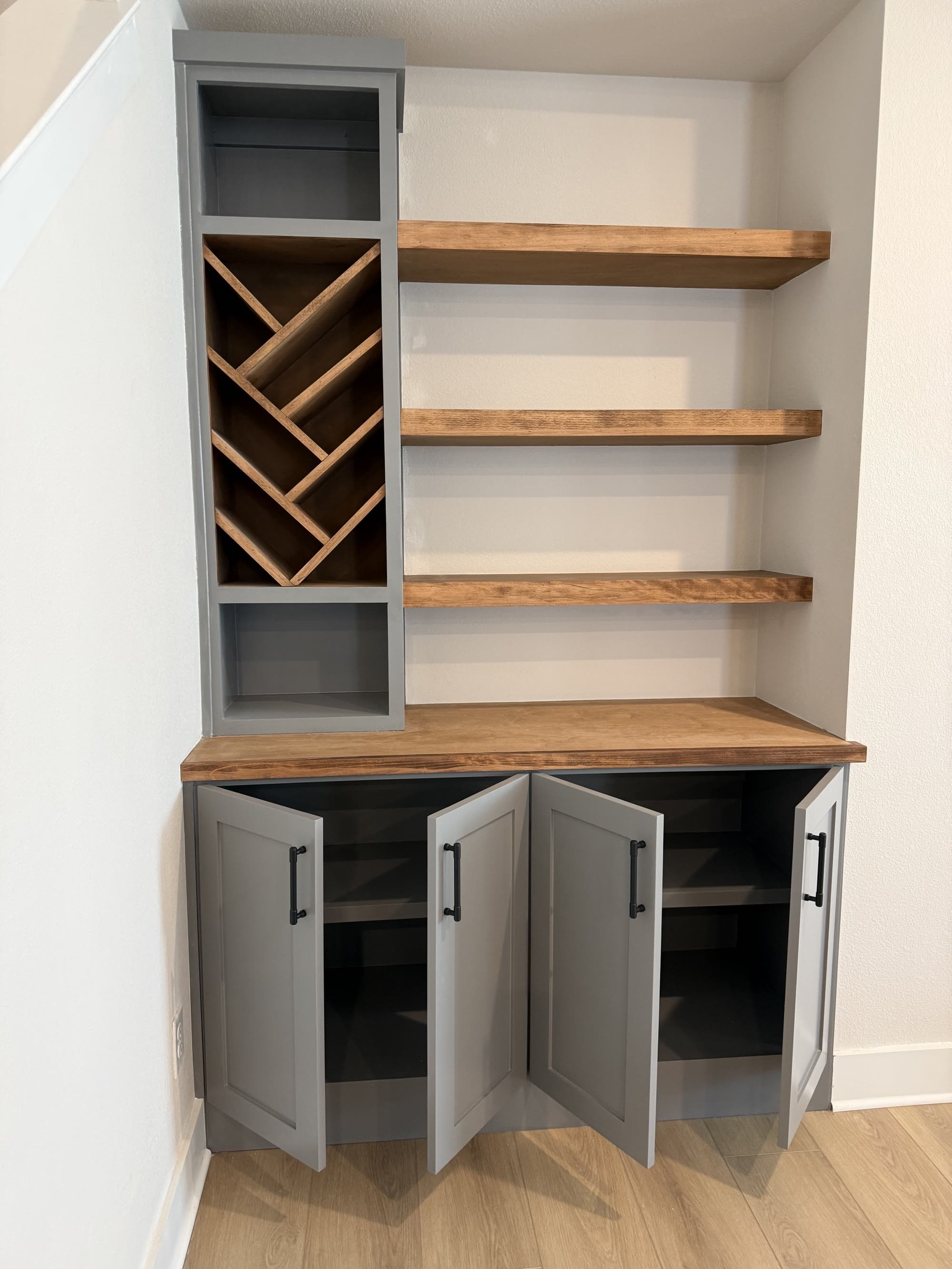 Custom built-in shelving and wine rack cabinetry with a stained wood countertop