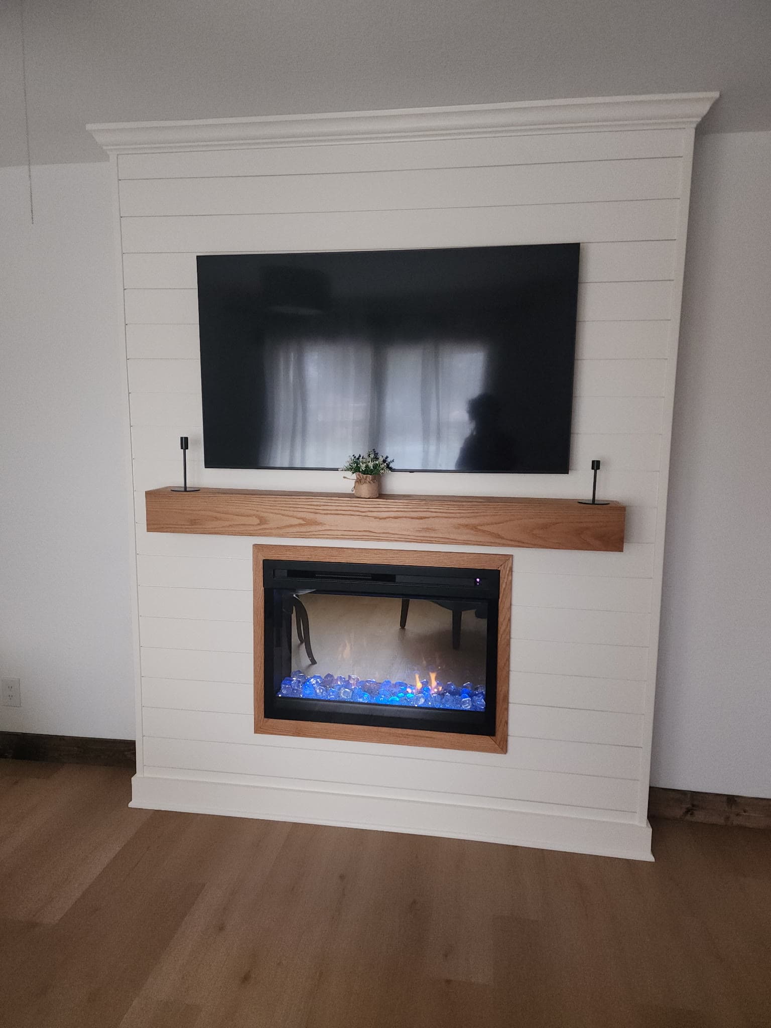 Custom shiplap fireplace built-in with a live-edge wood mantle and TV niche