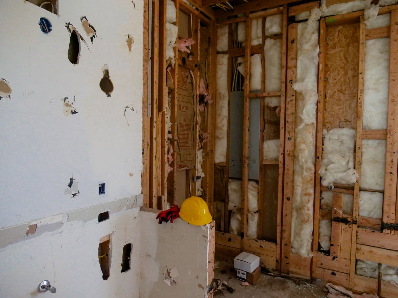 Interior room mid-renovation with demolition tools and construction materials